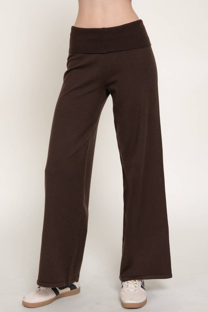 Side view of the brown fold over waist sweater pants showing the wide leg drape and sneakers