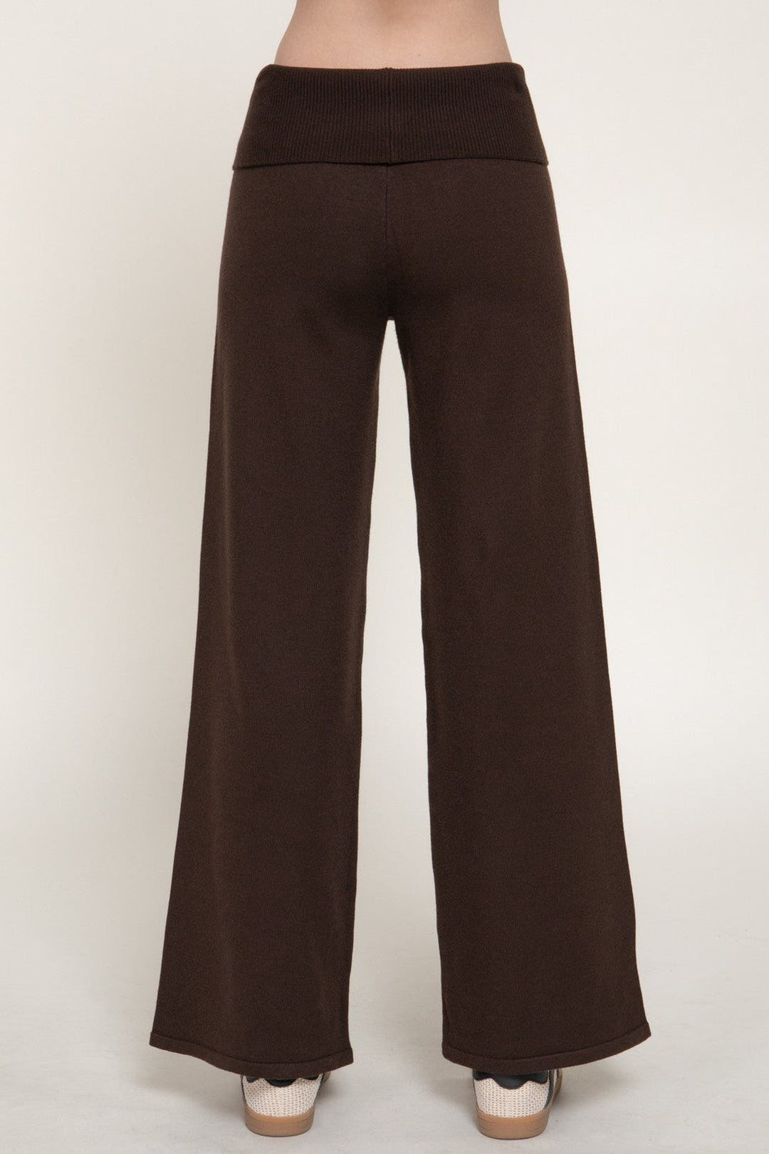 Front close view of the brown fold over waist sweater pants with wide leg and sneakers