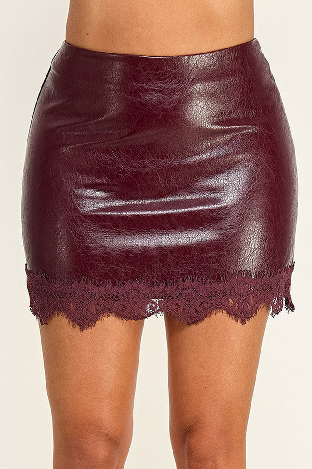 Close up of the scalloped lace hem on the faux leather mini skirt, shown in burgundy