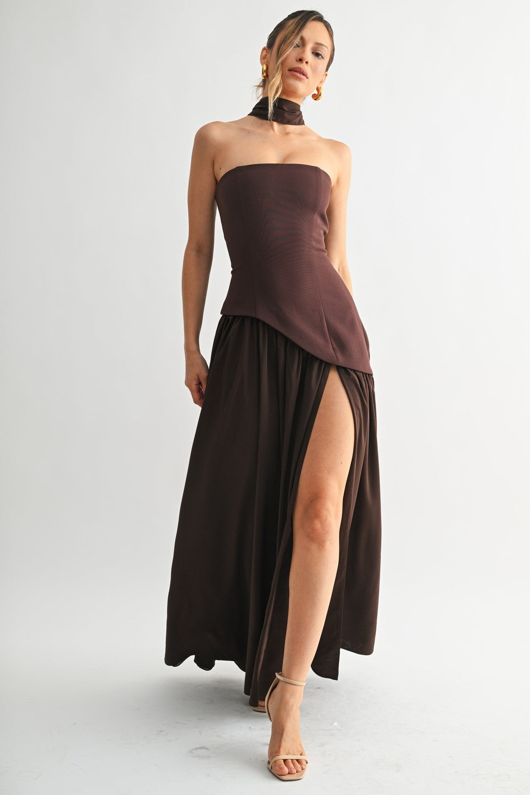 Brown strapless maxi dress with dramatic high slit, walking
