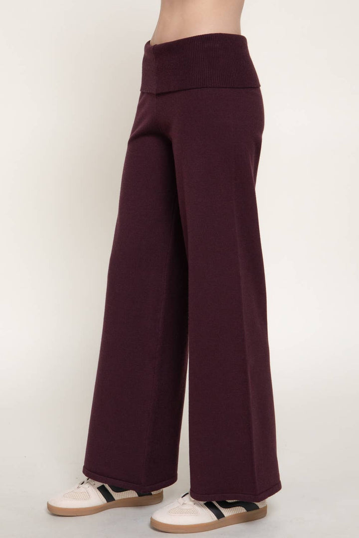 Front close view of the burgundy fold over waist sweater pants with wide leg and sneakers