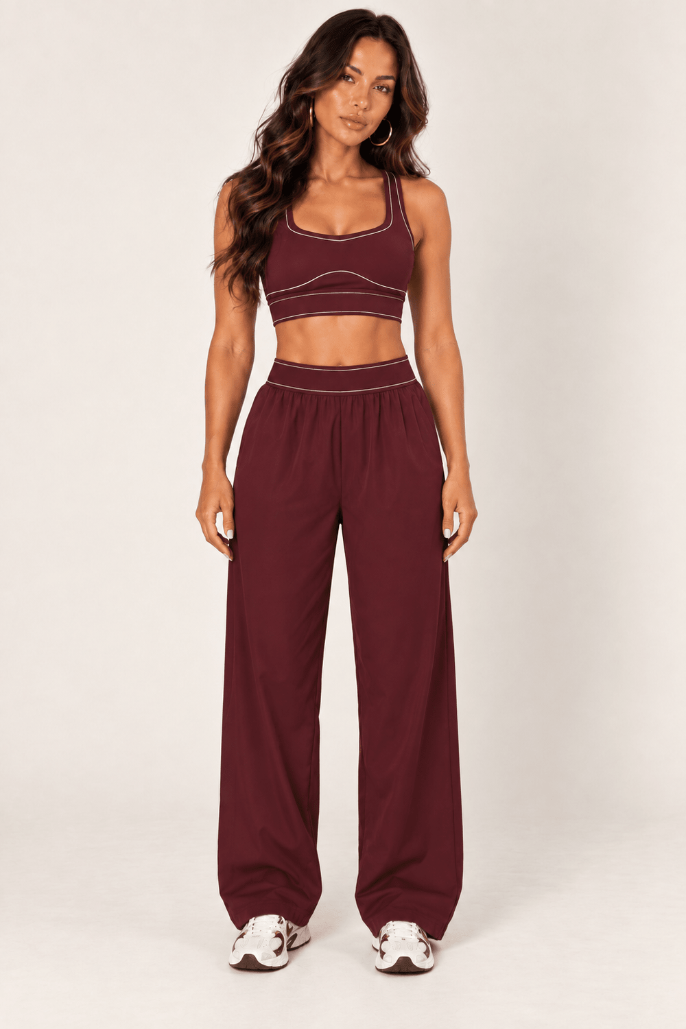 Burgundy sports bra and relaxed nylon track pants coordinating activewear set