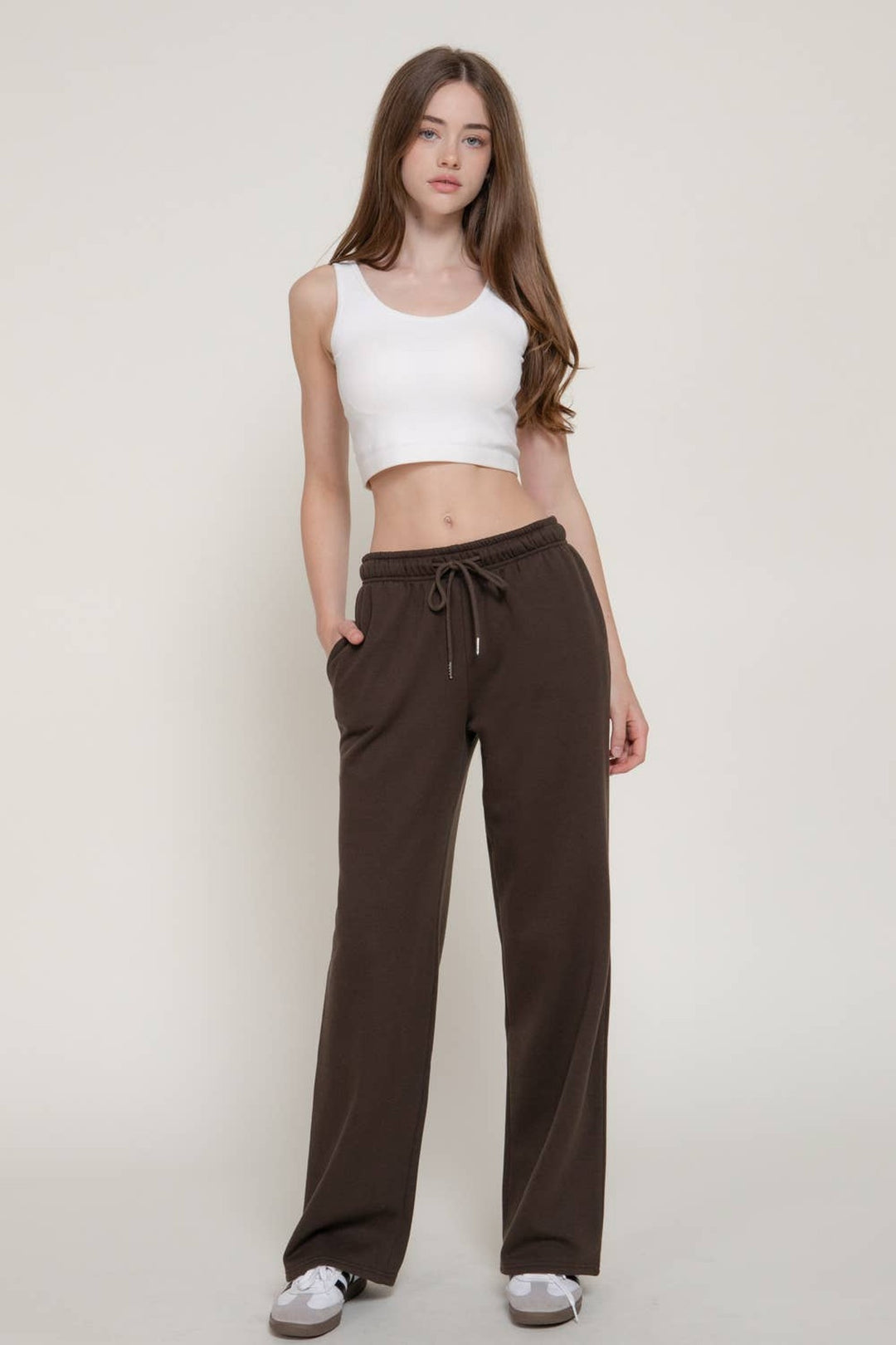 Full-length view of the Dark Brown Fleece Joggers with a white crop tank and sneakers, a fall lounge outfit