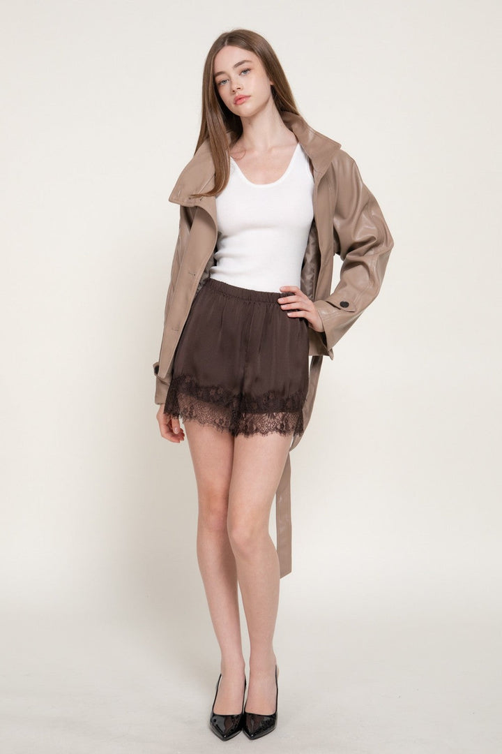 Full-length view of the Dark Brown Lace Trim Satin Shorts with a trench coat and black heels, a fall outfit