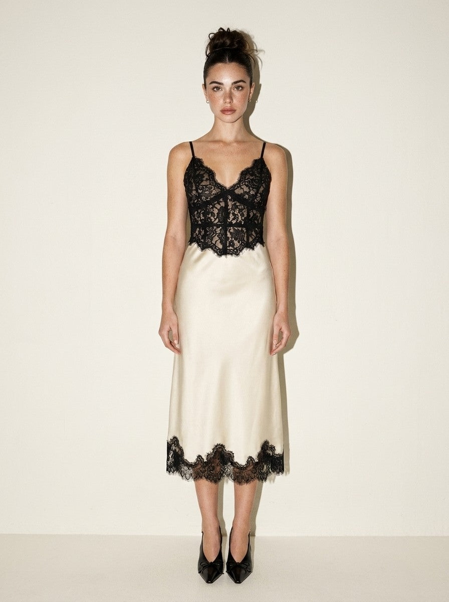 Front view of the Ivory Black Lace Midi Dress: sheer black lace corset bodice over an ivory satin bias-cut skirt