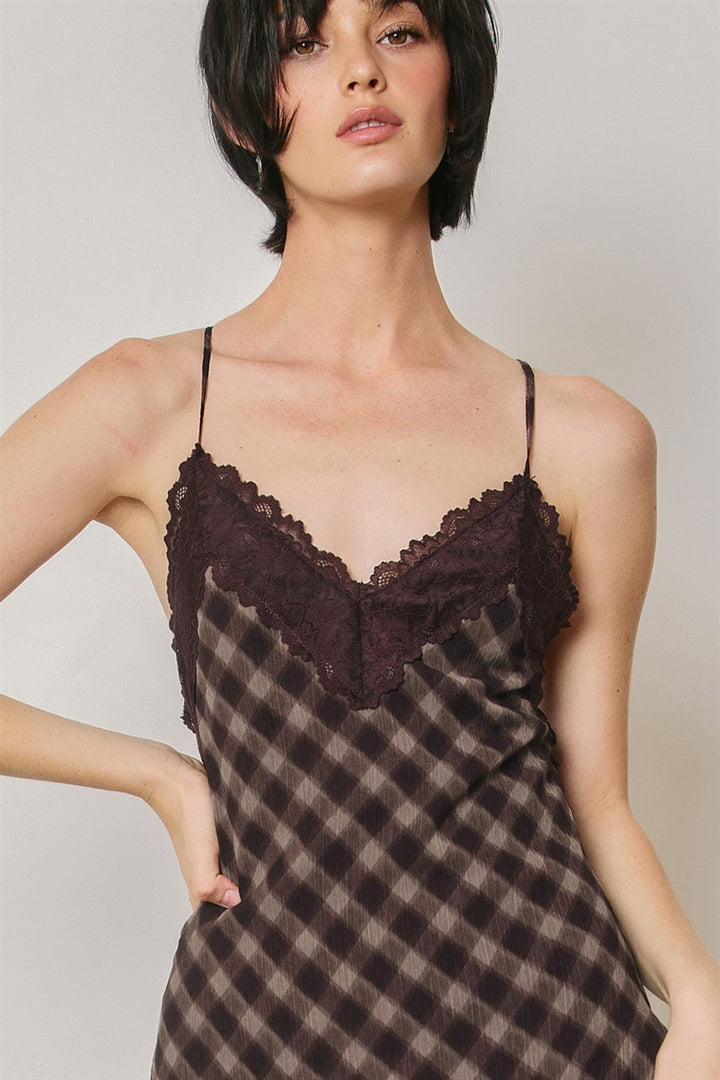 Close up of the lace trim deep V-neckline on the espresso checkered slip dress