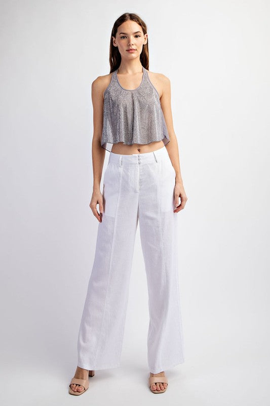 model is wearing Off White Stretch Linen Tailored Trousers with beige heel sandals and metallic top 