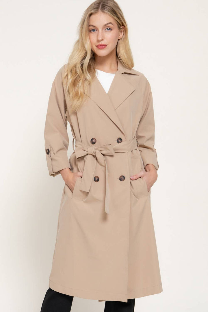 Front view of the Light Khaki Belted Trench Coat with lapel collar over a white tee and black pants, a fall outfit