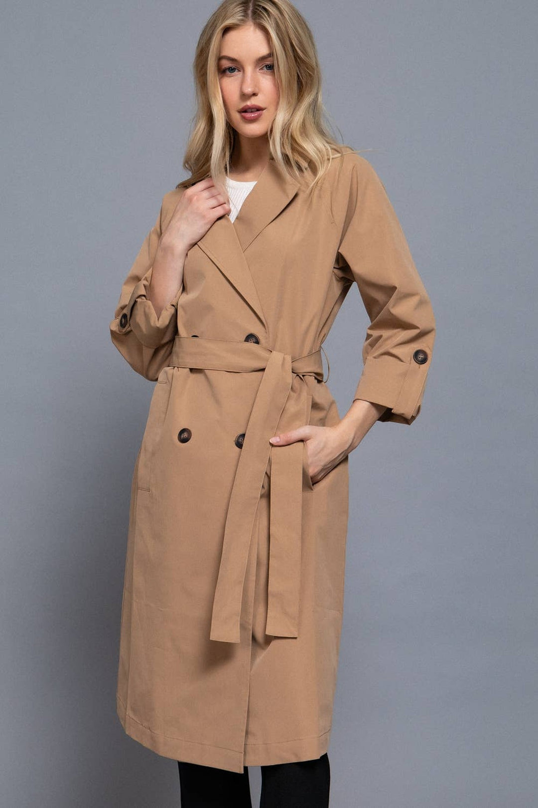 Three-quarter view of the light khaki belted trench coat with V-neck lapel collar and button front