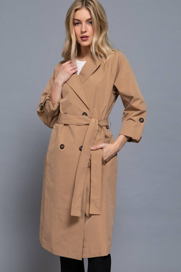 Three-quarter view of the light khaki belted trench coat with V-neck lapel collar and button front