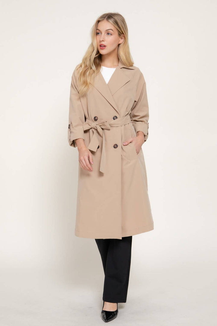 Full-length view of the light khaki trench coat with black pants and heels, a fall workwear outfit