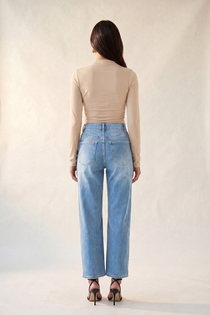 Light wash side seam straight leg jeans worn with a cream knit top, front view