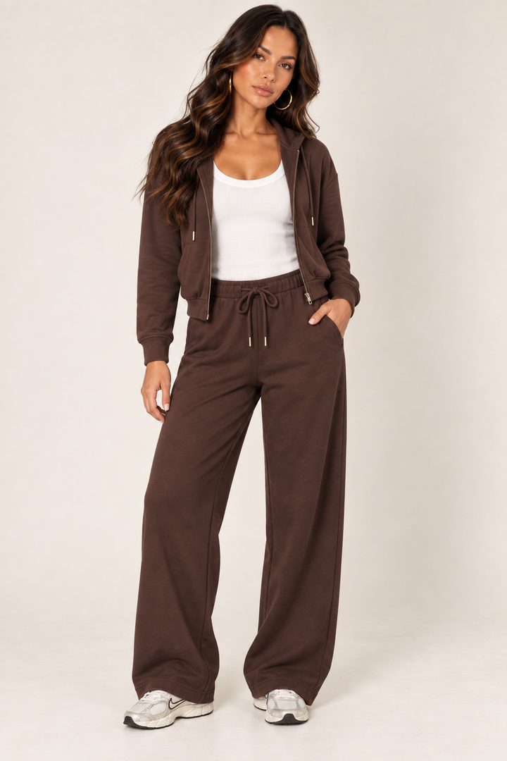 Chocolate cropped zip hoodie and wide-leg sweatpants styled with a white ribbed tank and Nike sneakers