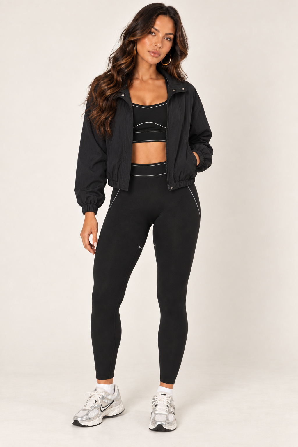Black LOVE TREE cropped windbreaker worn fully open over a black contrast-stitch sports bra and contour leggings, with white and silver sneakers.