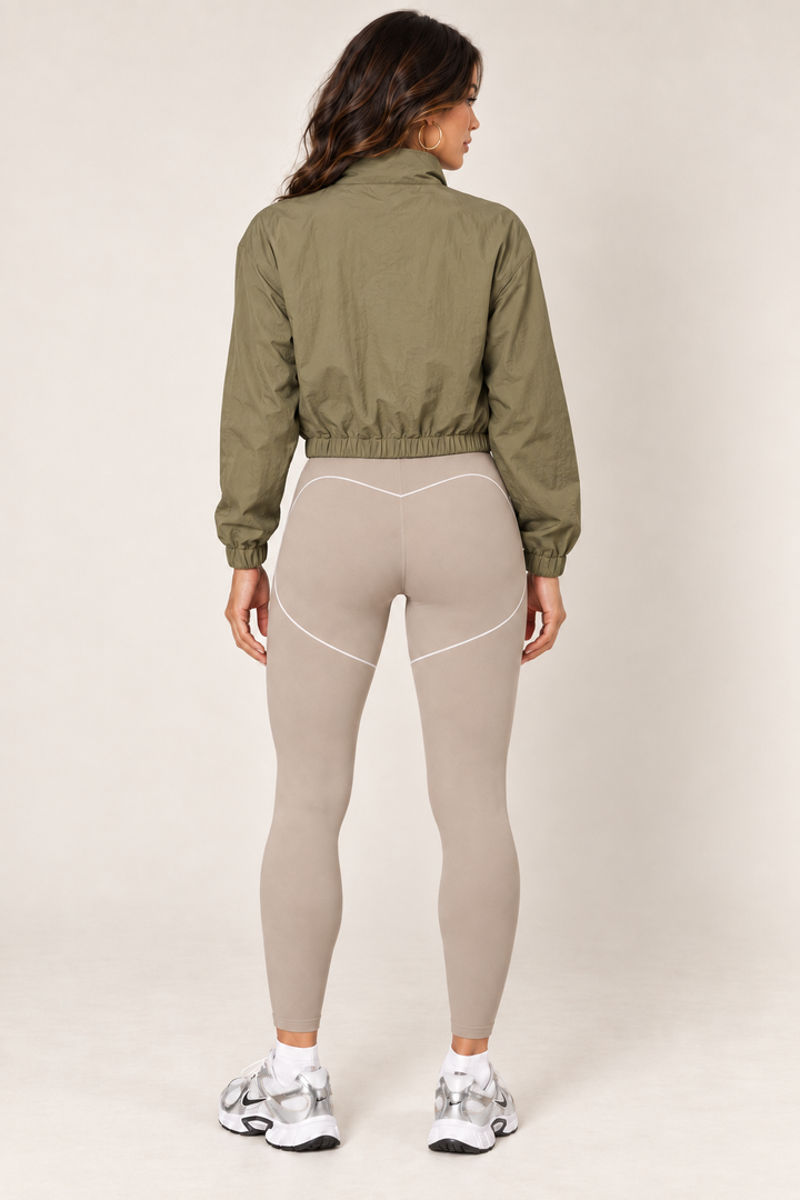 Olive cropped windbreaker with taupe leggings — full back