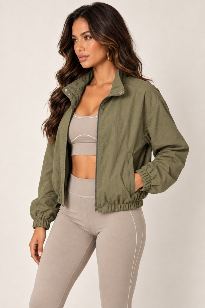 Olive cropped windbreaker with taupe leggings — thigh up left open
