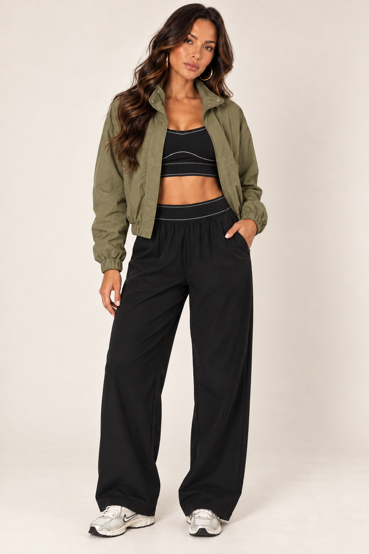 Olive cropped windbreaker with black track pants — full front open