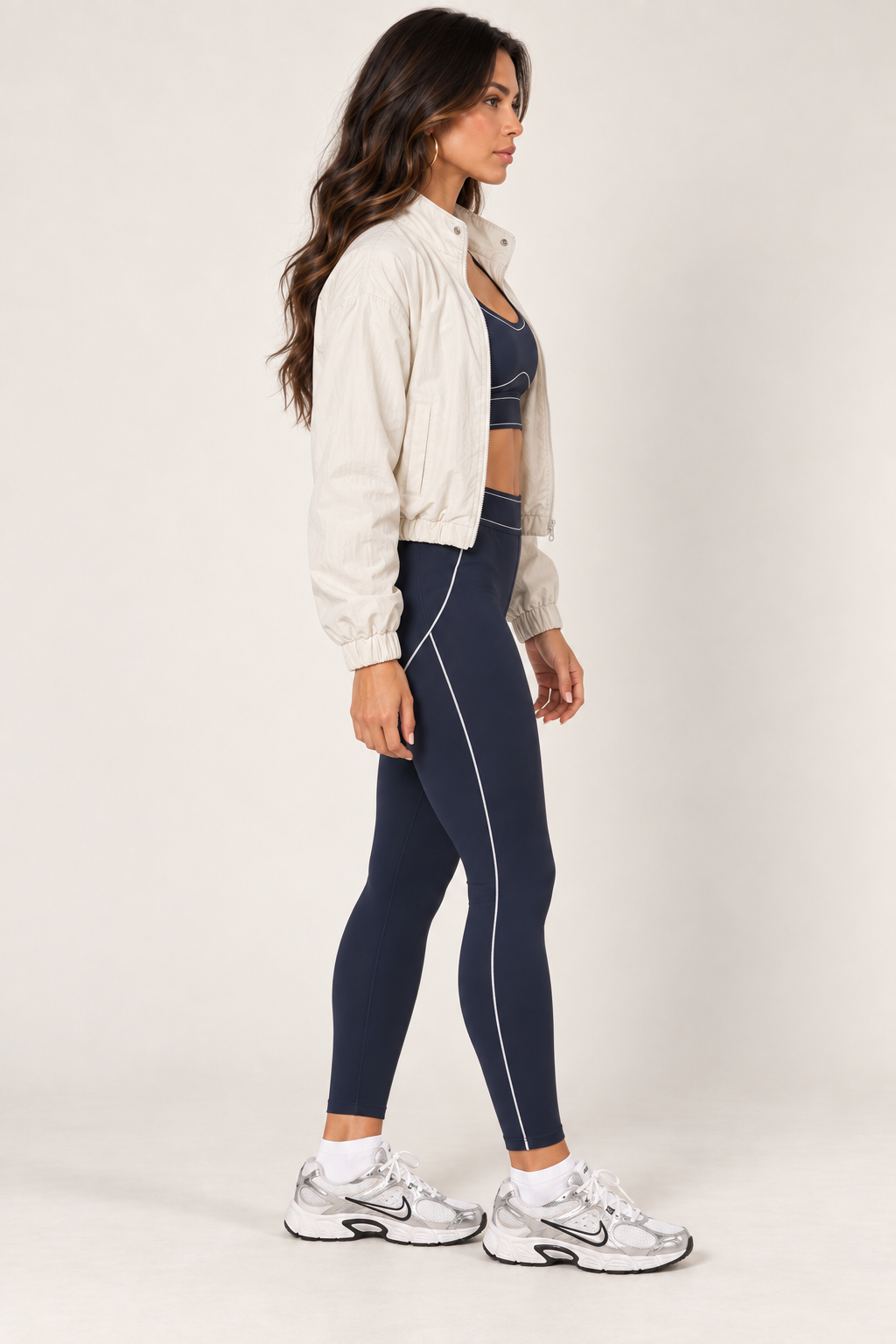 Cream LOVE TREE cropped windbreaker with dark navy sports bra and leggings; side view.