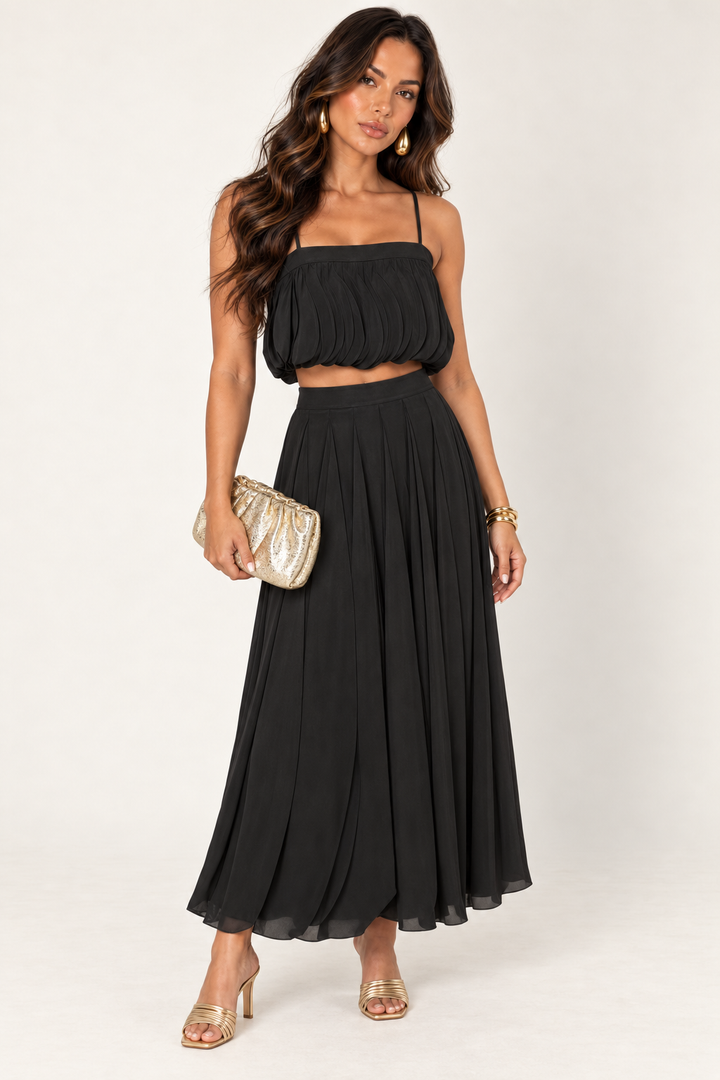 ALX hair-down model wearing black petal layer skirt set styled with the gold ruched clutch