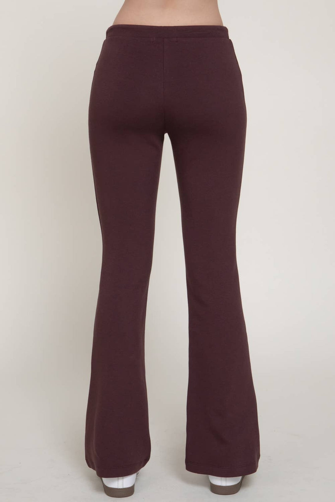 Back view of the maroon flare knit pants with white sneakers, a Thanksgiving weekend look