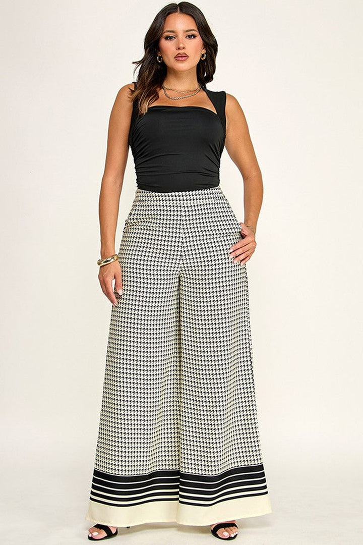 Off white and black checkered palazzo pants worn with a black top, full length front view