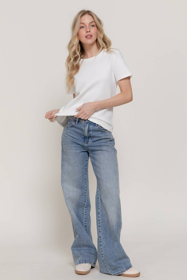 Full-length view of the Off White Soft Knit Tee with light-wash wide leg jeans, a casual fall outfit