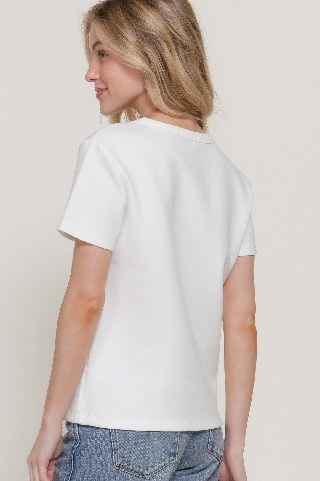 Back view of the off white short sleeve soft knit tee with jeans