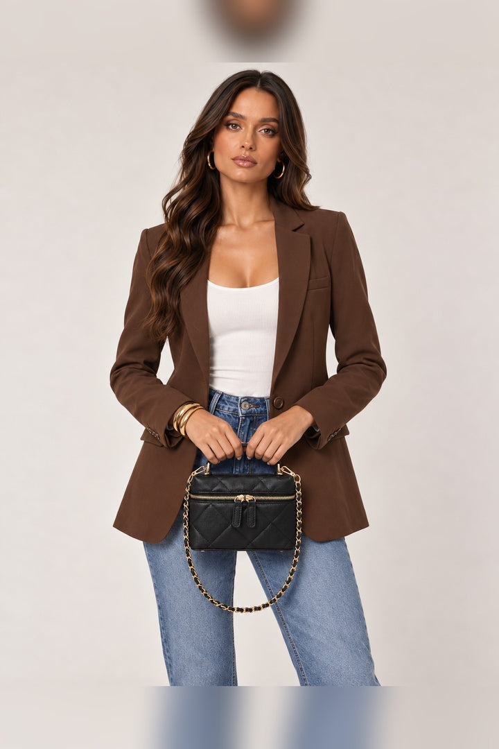 Model carrying the black quilted vegan leather bag by its top handle, a Christmas party accessory