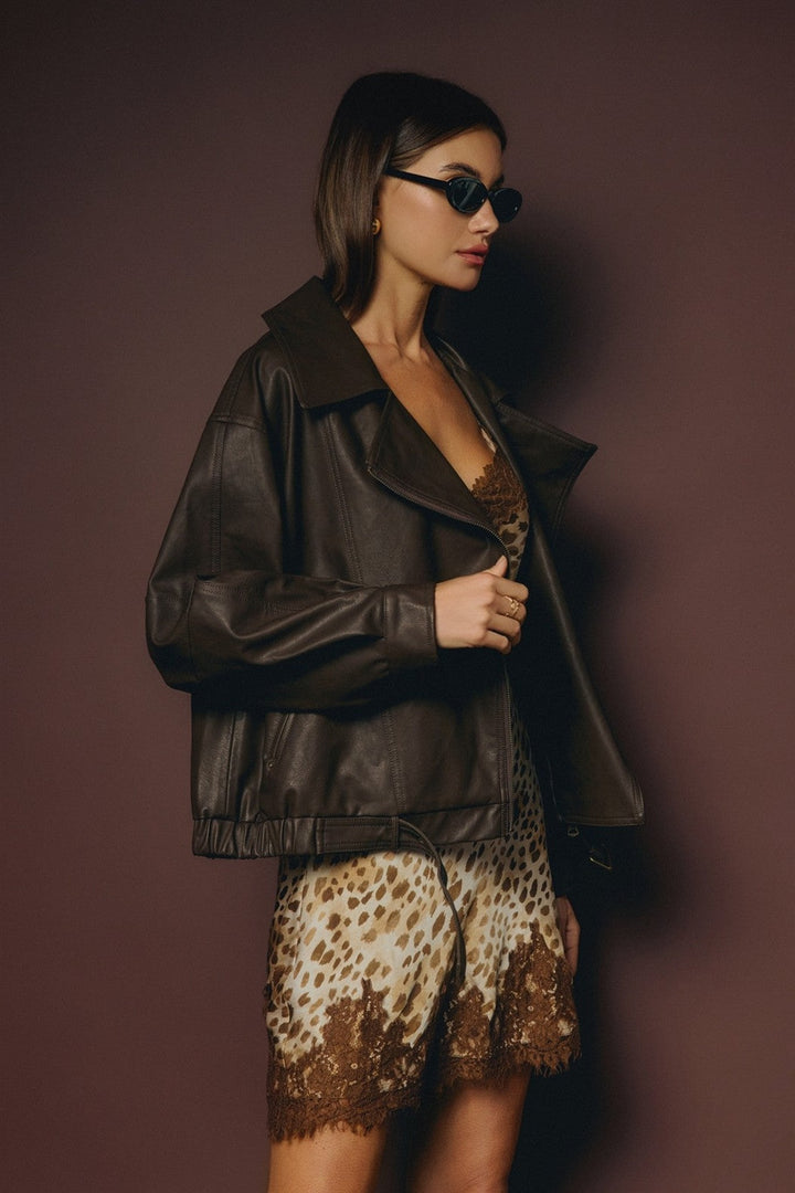 Side view of the leopard satin slip dress under a black leather jacket