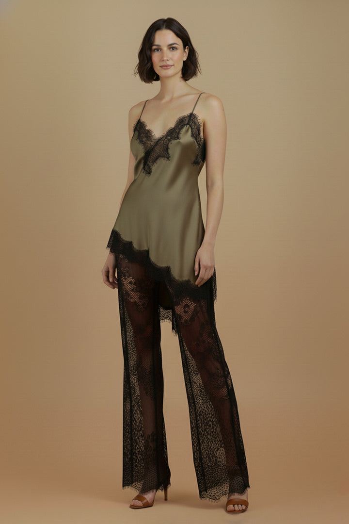 Full-length front view of the Khaki Satin Lace Pants Set by Skylar Rose at Styled by ALX, worn by a brunette model. The olive satin camisole has fine straps and asymmetric black eyelash lace trim, paired with black floral lace wide-leg pants and tan open-toe heels against a warm neutral background.