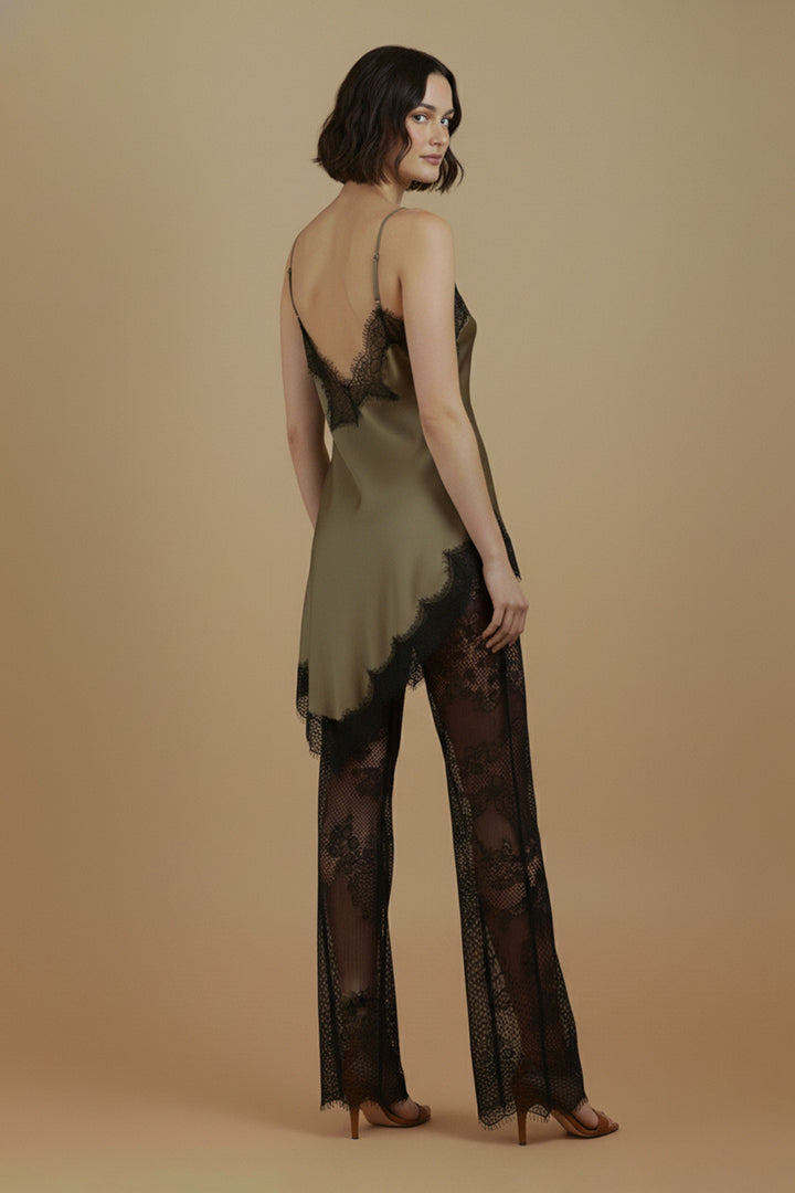 Rear three-quarter model view of the Khaki Satin Lace Pants Set by Skylar Rose at Styled by ALX. Adjustable olive straps frame the low V back with black eyelash lace, while the satin top drapes over black floral lace wide-leg pants, styled with tan open-toe heels.