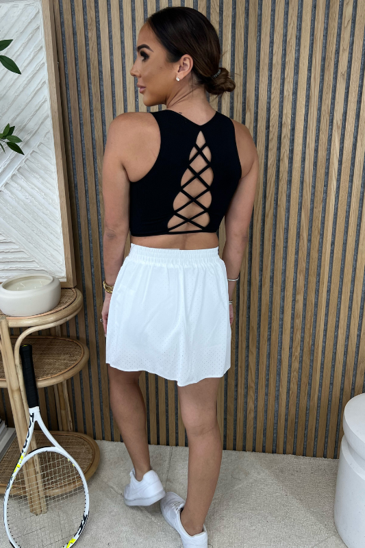 STYLED BY ALX COUTURE MIAMI BOUTIQUE Black Scoop Neck Back Lace-Up Top Paired With White Black Detailed Tennis Skort For A Tennis Outfit