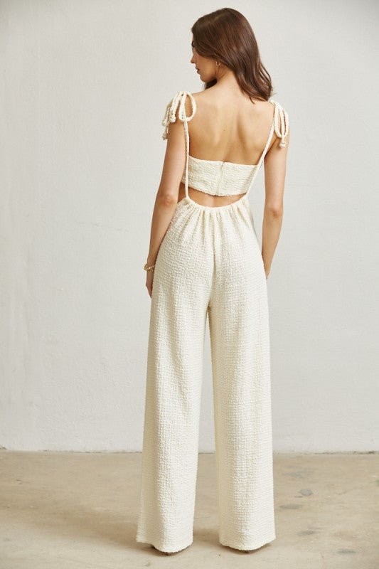 Side tie straps finished with pearl-like beads on a cream bandeau top