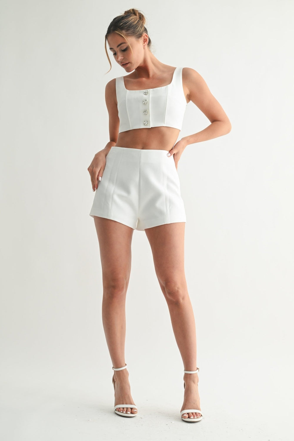Wide straps on the structured white crystal button crop top
