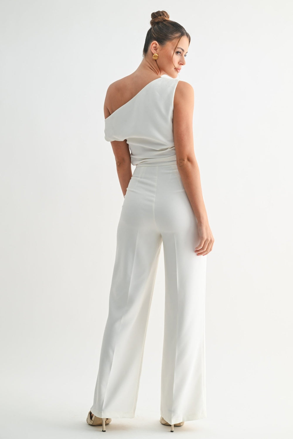 Clean structured white jumpsuit styled for formal evening events