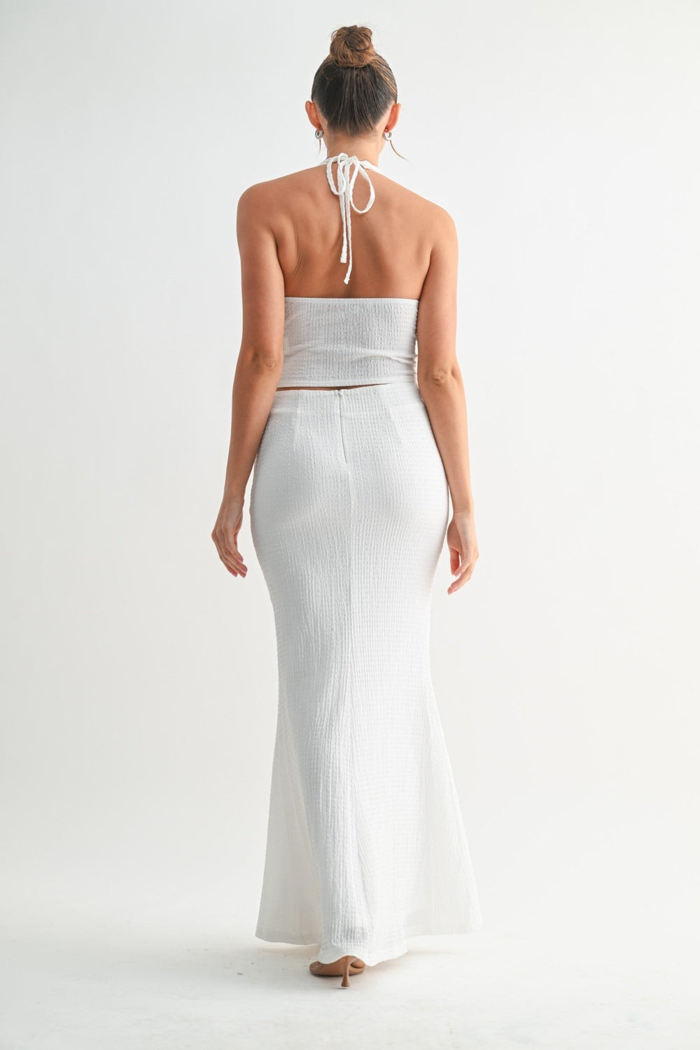 Sculpting white maxi skirt paired with a matching halter crop top
