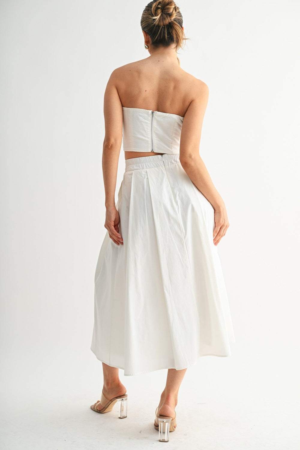 Soft pleats falling through the matching skirt