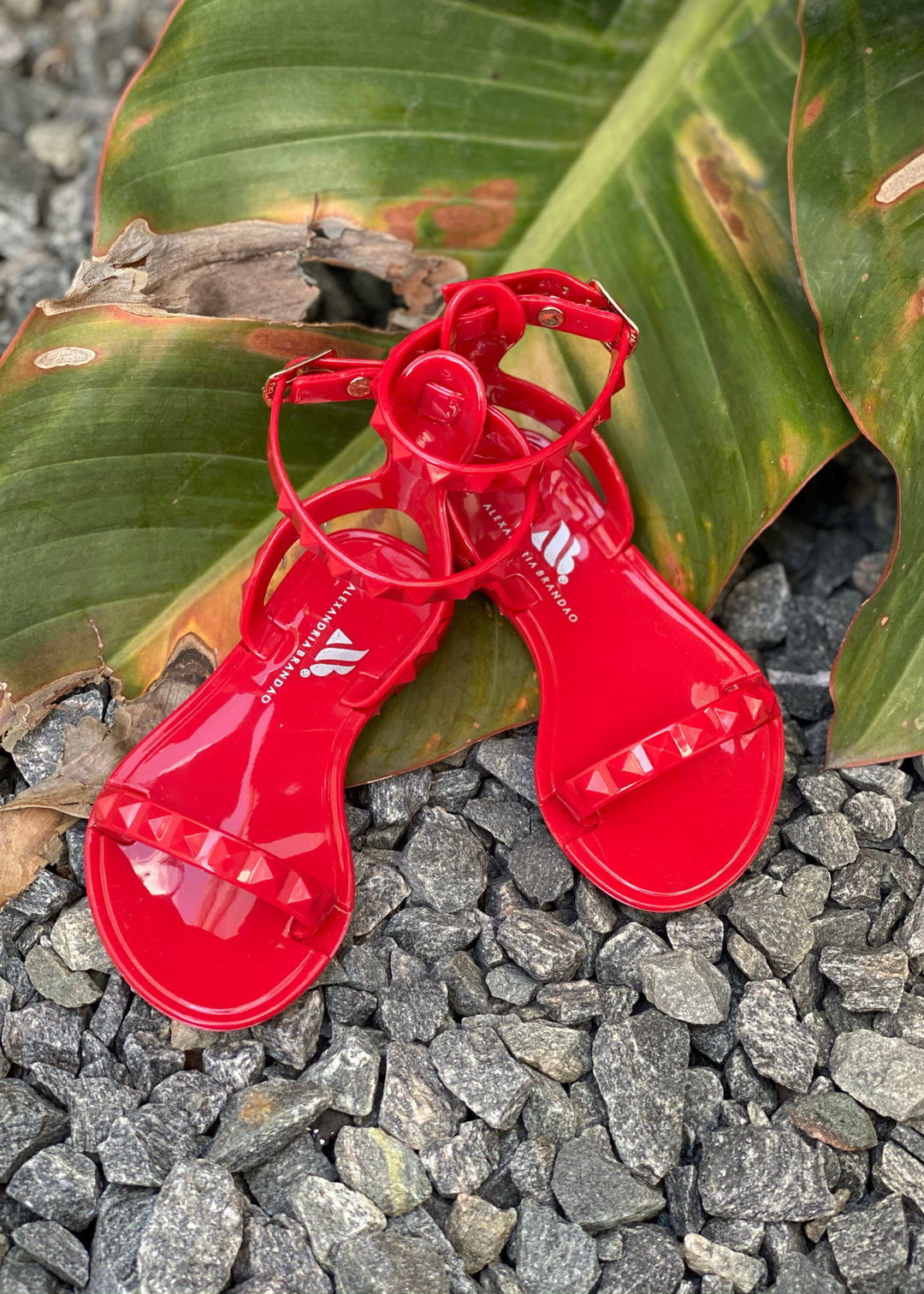 Aria Kids red jelly sandals with thin strap across the toes and thin ankle strap. Shoes for beach and pool days. Wear them all year long with a casual chic look