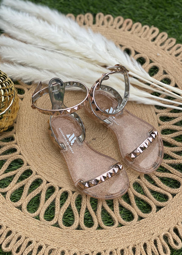 Aria Kids rose gold jelly sandals with studded thin strap across the toes and thin ankle strap. SANDALS FOR BEACH OR POOL DAYS. JELLY SANDALS FOR KIDS. ROSE GOLD JELLY SANDALS