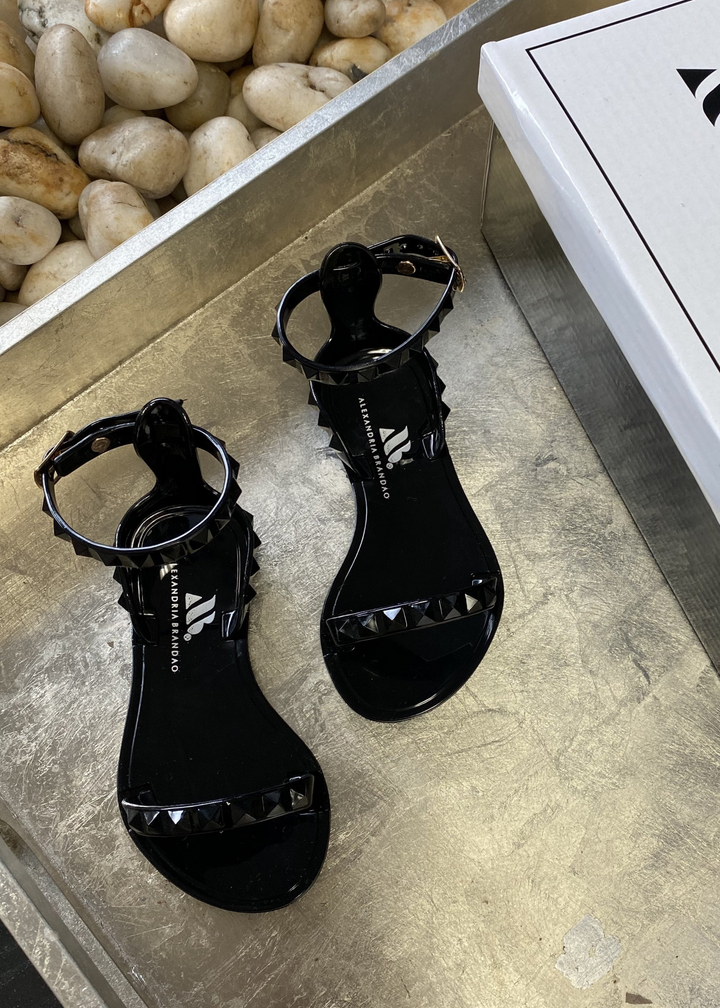 Aria Kids black jelly sandal with a thin strap across the toes and a thin strap around the ankle.