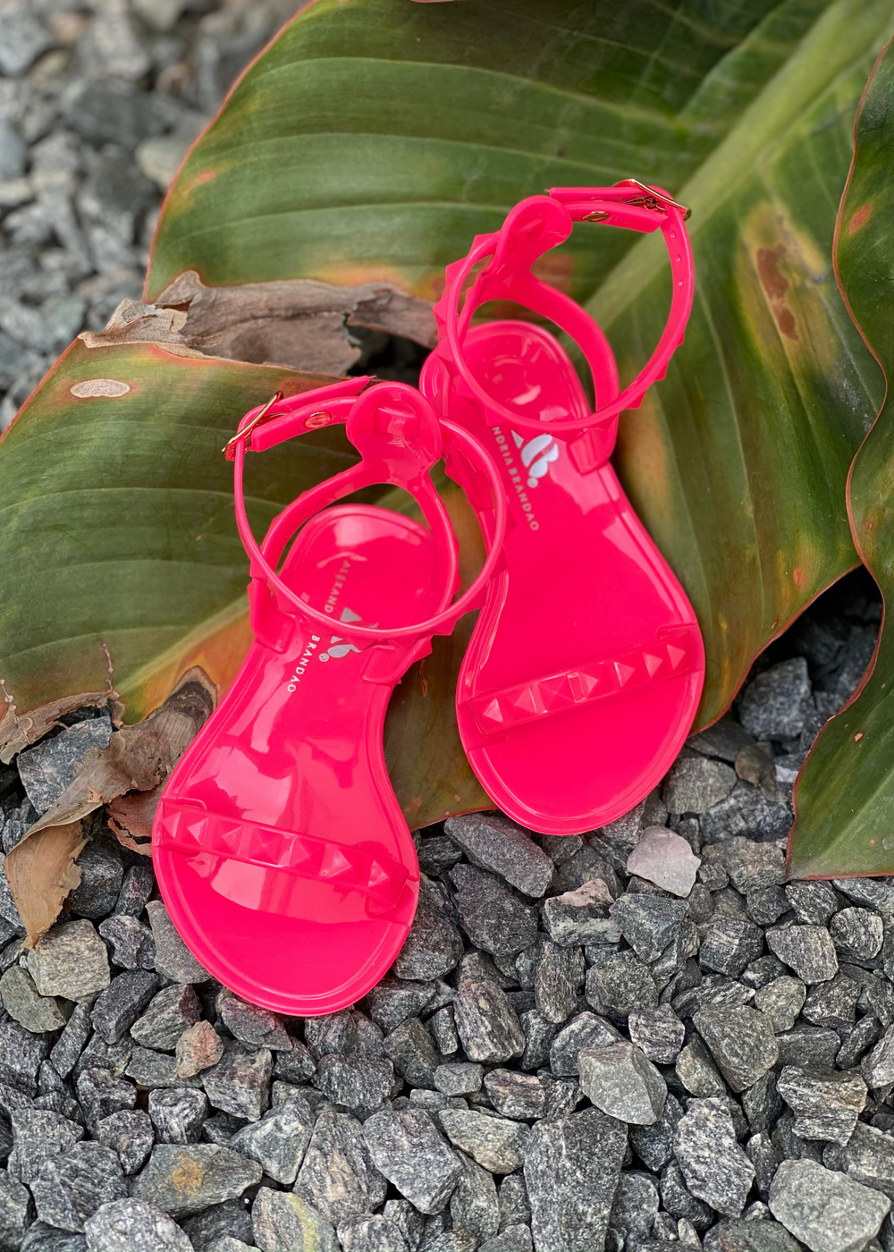 Aria Kids neon pink jelly sandals with thin strap across the toes and thin ankle strap.
