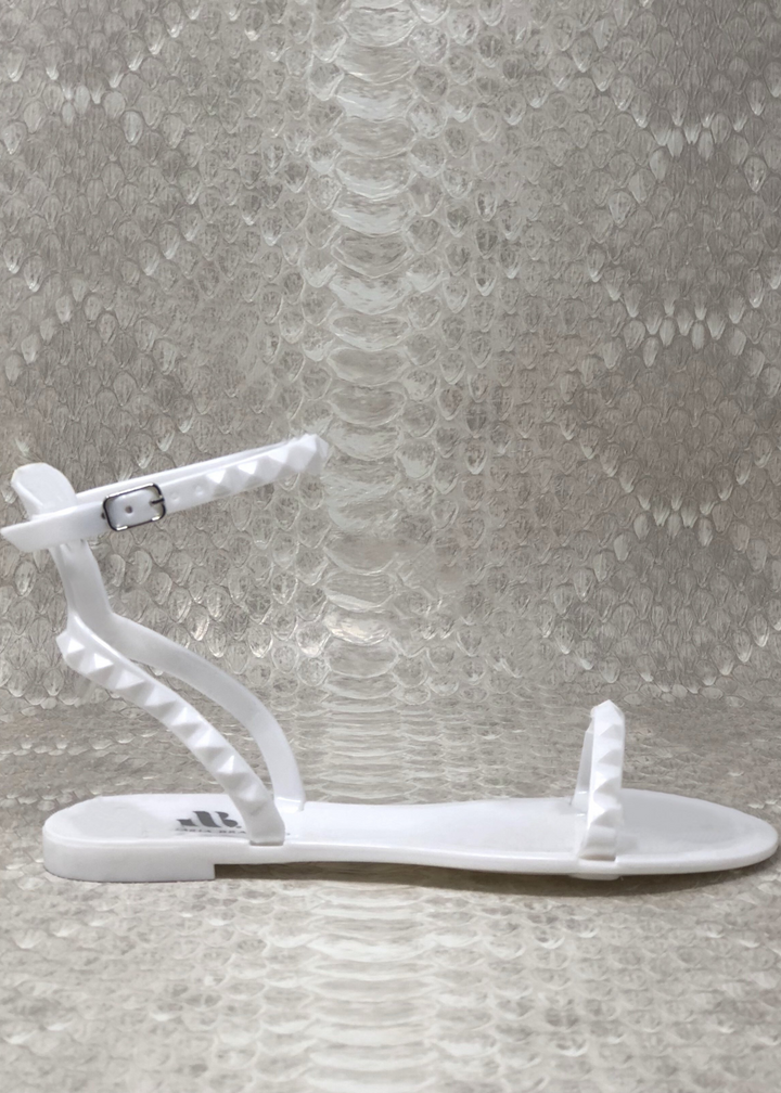 WHITE STUDDED ARIA SANDAL THAT WRAP AROUND THE ANKLE WITH A BUCKLE AND ONE STRAP IN THE FRONT. Side view